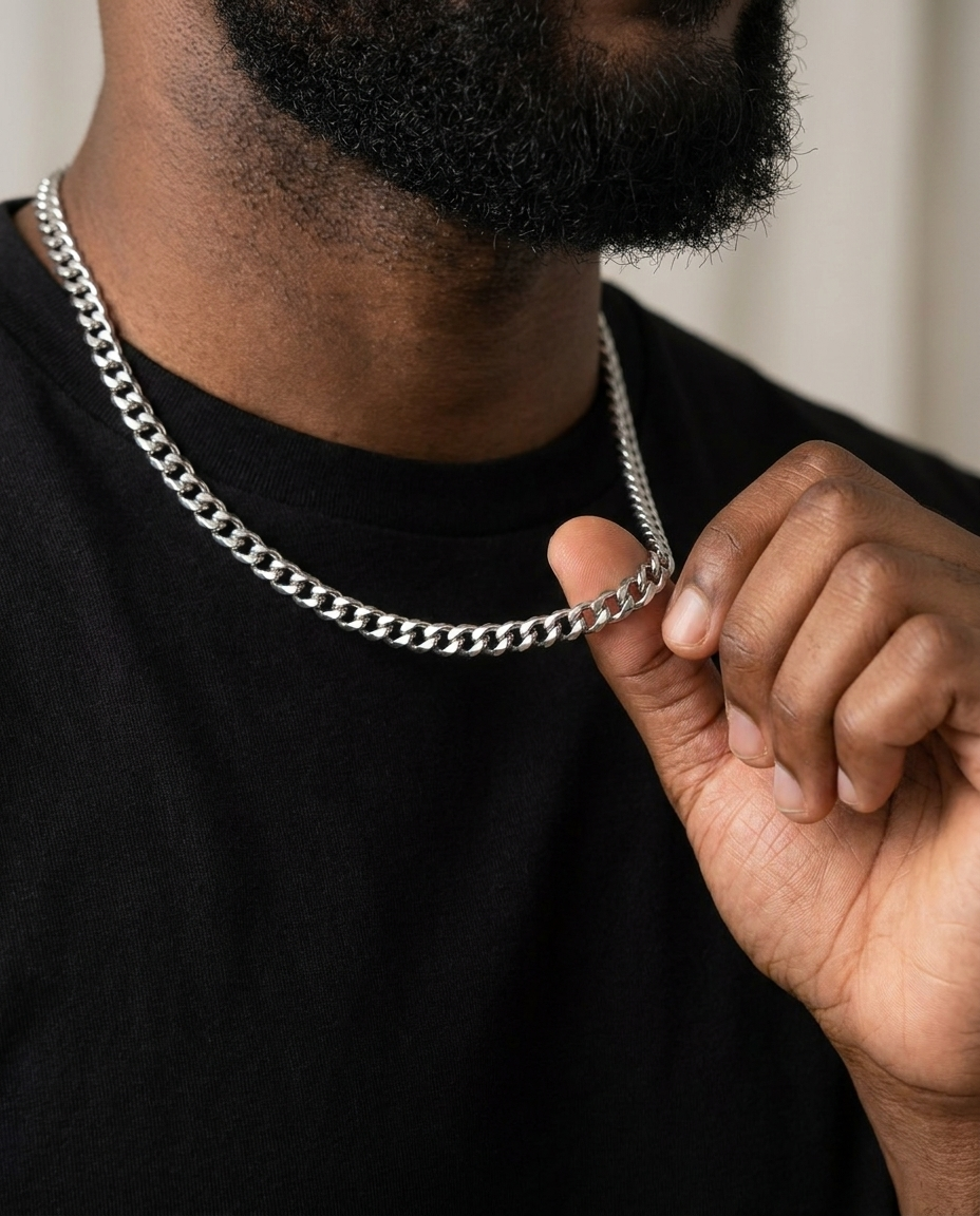 Man wearing a silver Cuban link chain with a black T-shirt