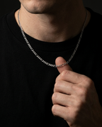 Man wearing a 2mm silver Figaro chain with a black T-shirt