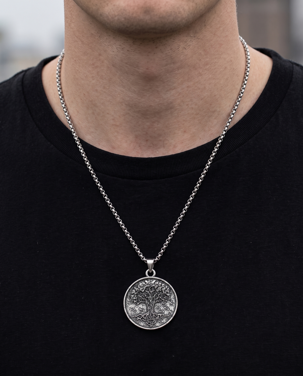 Man wearing the Tree of Life pendant necklace on a rolo chain